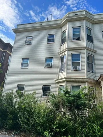 a front view of a house with plants