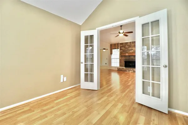 an empty room with wooden floor and windows