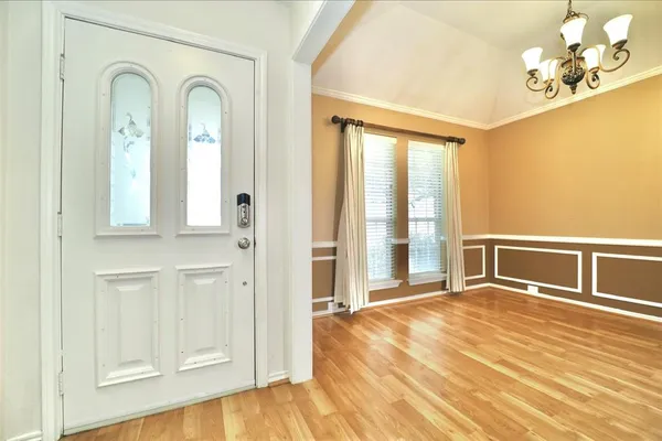 a view of a livingroom with wooden floor and a chandelier