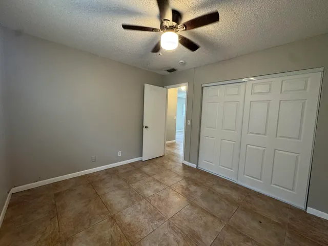 an empty room with fan and entrance