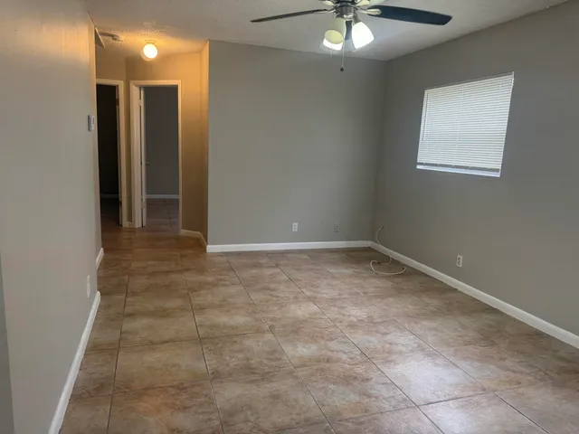 a view of an empty room with window and bathroom