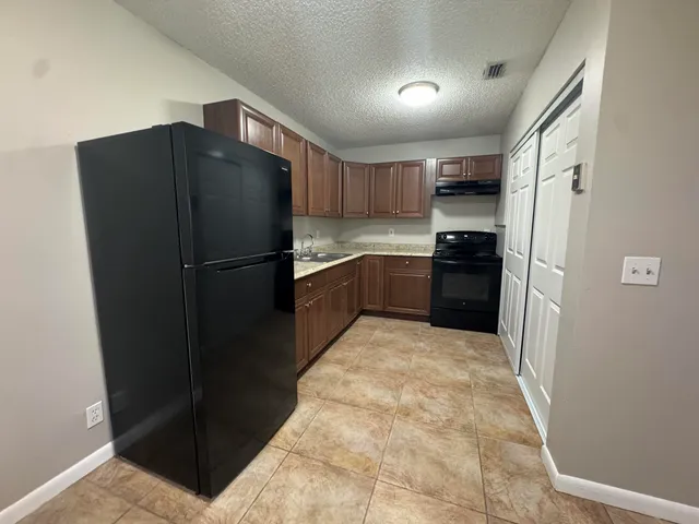 a kitchen with a refrigerator and a sink