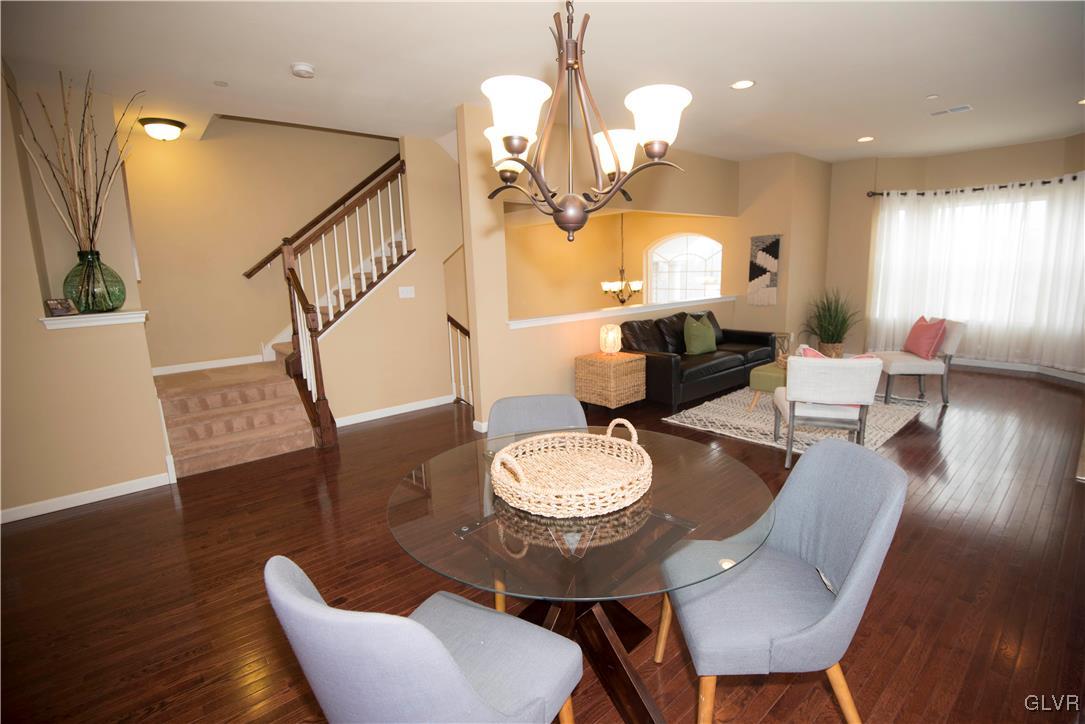2406 Gentle Hollow Road Whitehall, PA 18052 - Photo 15 of 37 a dining room with wooden floor a chandelier a glass table and chairs
