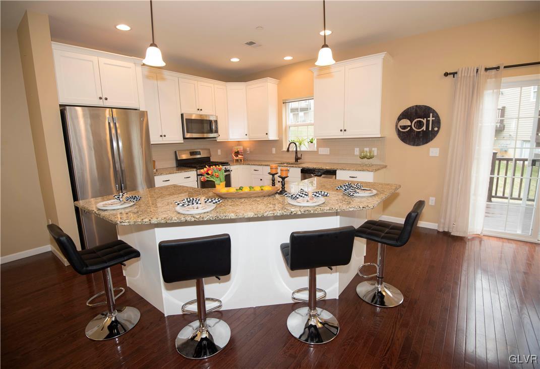 2406 Gentle Hollow Road Whitehall, PA 18052 - Photo 6 of 37 a kitchen with stainless steel appliances granite countertop a refrigerator a stove a sink and chairs with wooden floor