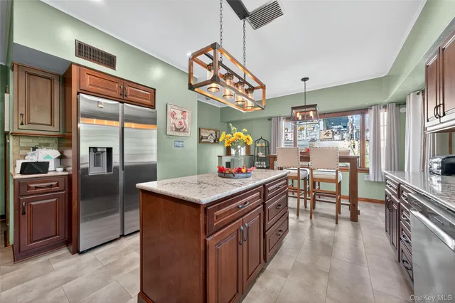 a kitchen with stainless steel appliances granite countertop a sink a stove and a refrigerator