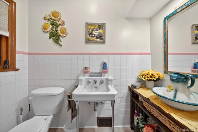 a bathroom with a sink a toilet and a mirror