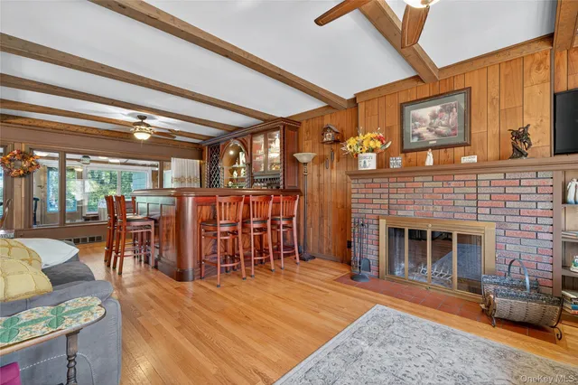 a living room with furniture a fireplace and a ceiling fan