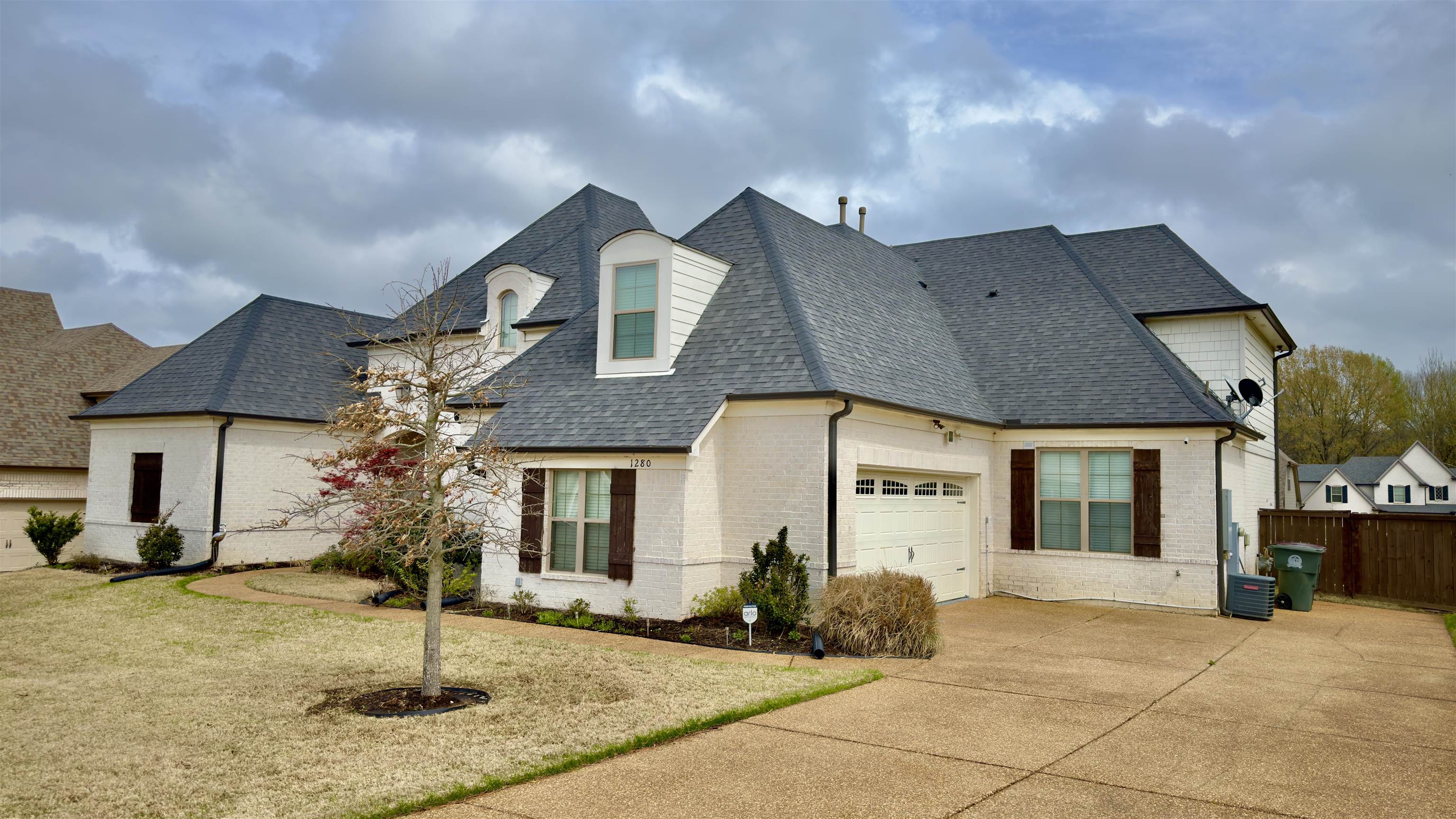 1280 Mountain Side Drive Collierville, TN 38017 - Photo 2 of 29 French country inspired facade with fence, an attached garage, concrete driveway, brick siding, and a shingled roof