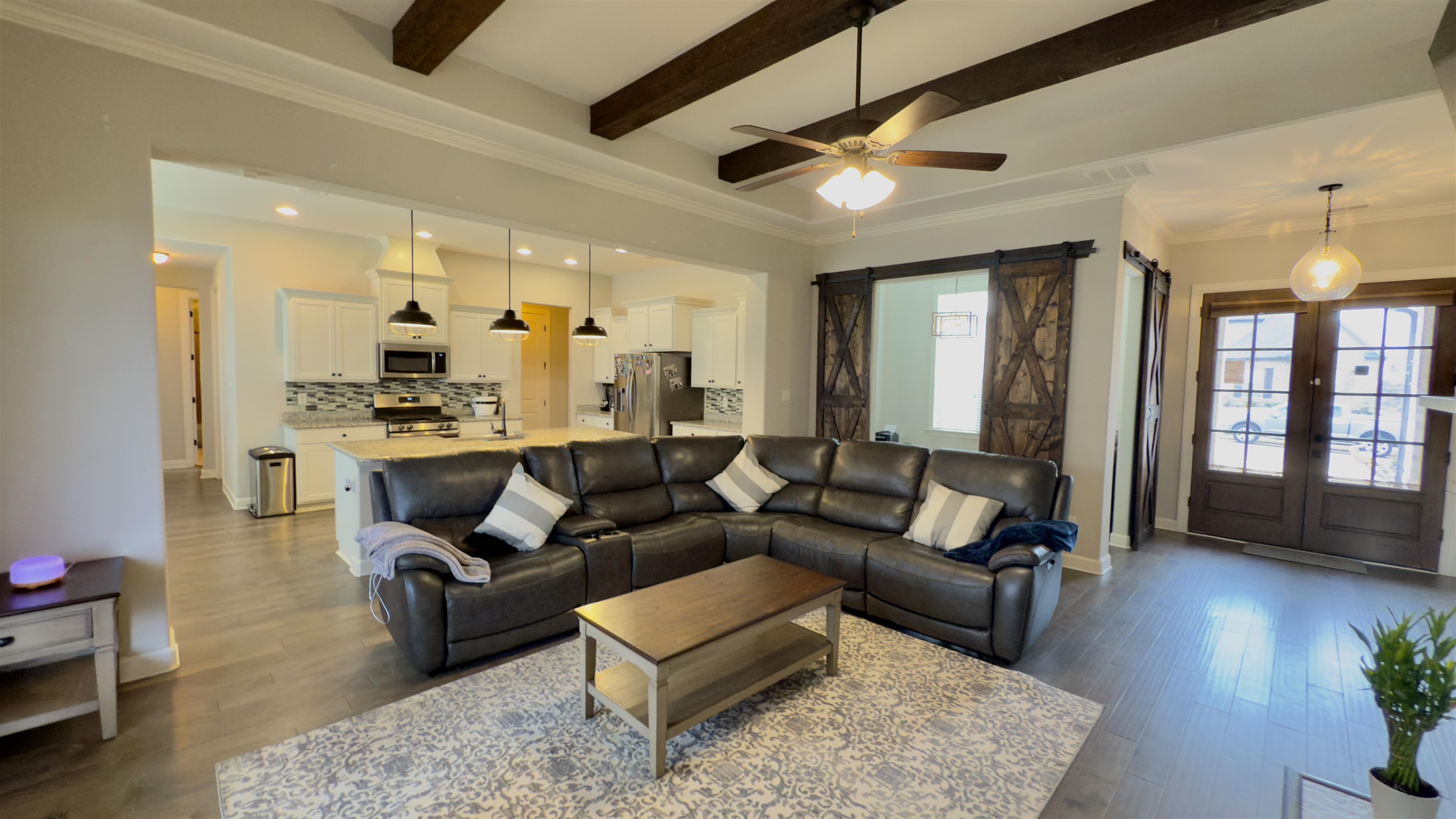 1280 Mountain Side Drive Collierville, TN 38017 - Photo 6 of 29 Living area featuring a barn door, a wealth of natural light, dark wood-style floors, and beam ceiling