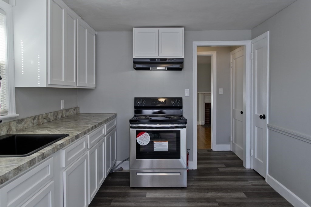 138 Appleton Street Springfield, MA 01108 - Photo 12 of 42 a kitchen with granite countertop a stove sink and cabinets
