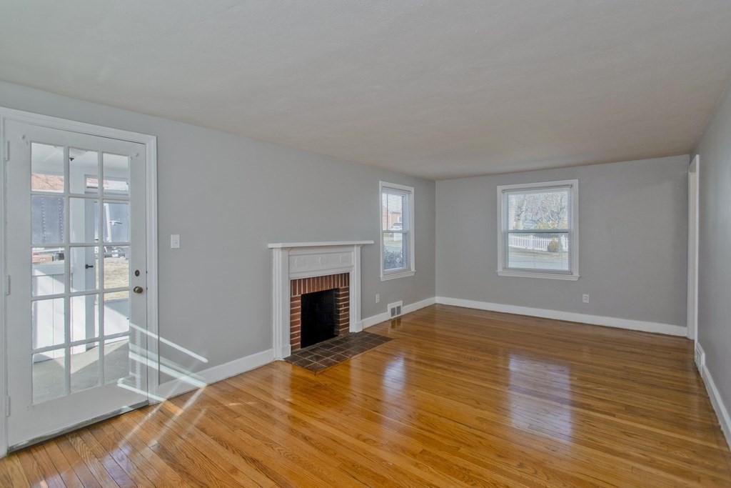138 Appleton Street Springfield, MA 01108 - Photo 6 of 42 a view of empty room with wooden floor and fireplace
