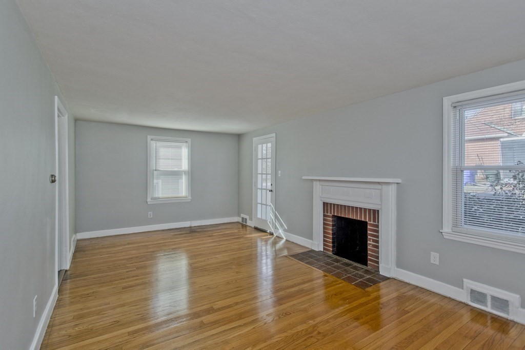 138 Appleton Street Springfield, MA 01108 - Photo 7 of 42 a view of empty room with wooden floor and fireplace