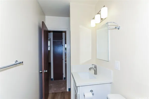 a bathroom with a sink a light fixture and a mirror