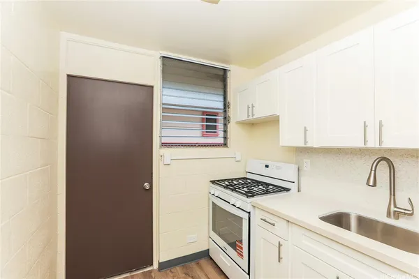 a kitchen with granite countertop a sink and a stove top oven