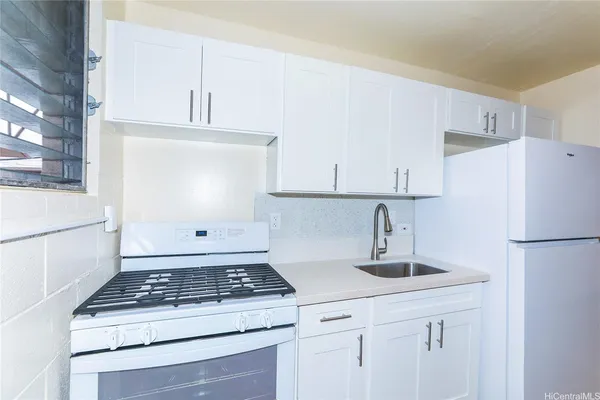a kitchen with white cabinets and white appliances