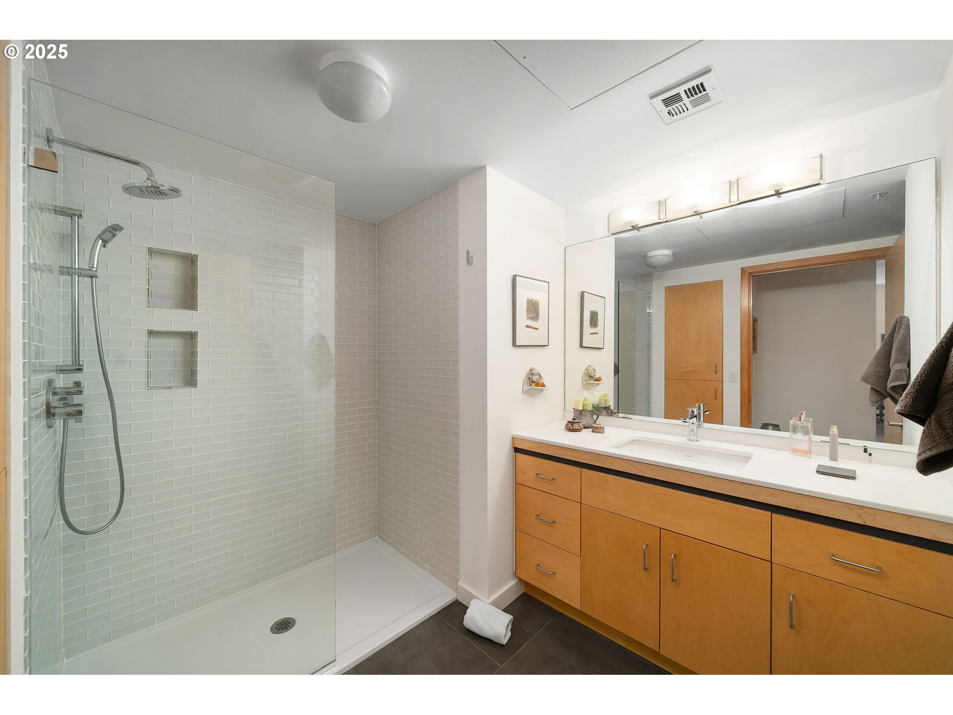 821 Northwest 11th Avenue, Unit 321 Portland, OR 97209 - Photo 30 of 48 a bathroom with a double vanity sink mirror and shower