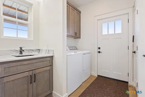 a room with a sink cabinets and a window