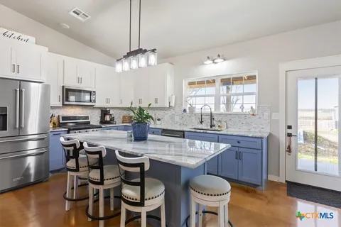 a kitchen with stainless steel appliances a dining table and chairs