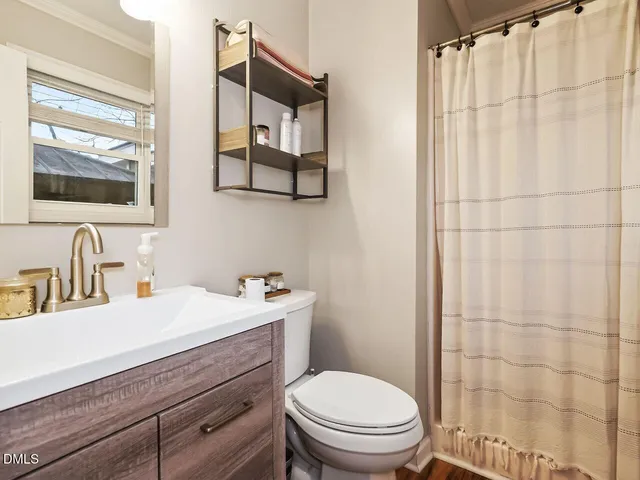 a bathroom with a sink a toilet and shower curtain