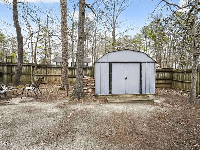 a view of backyard with a barn and a large tree