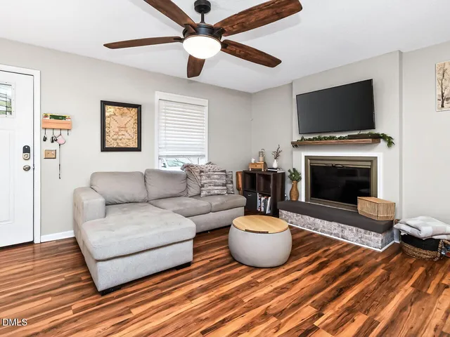 a living room with furniture a flat screen tv and a fireplace