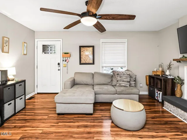 a living room with furniture and a wooden floor