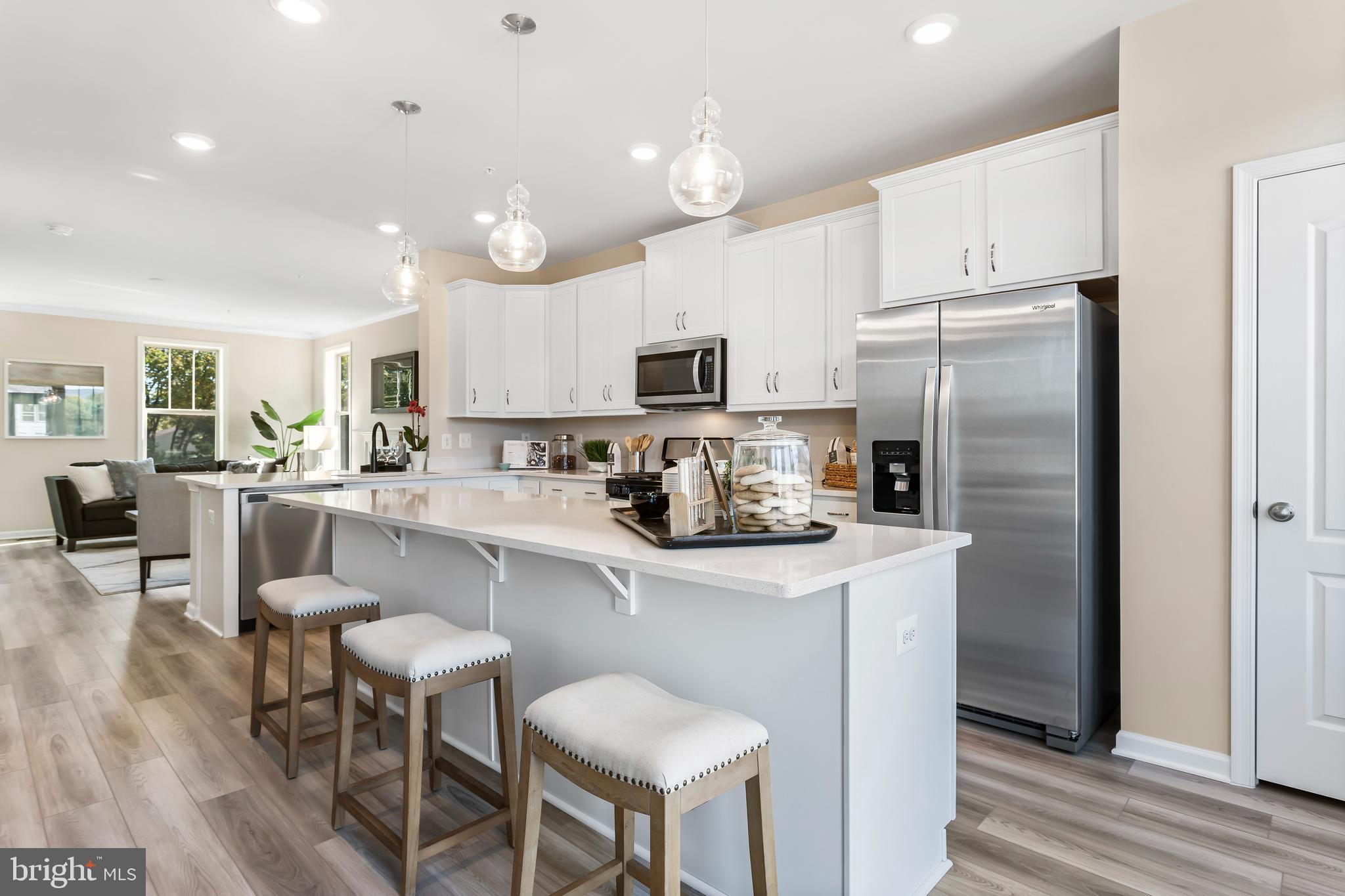 a kitchen with kitchen island white cabinets and stainless steel appliances