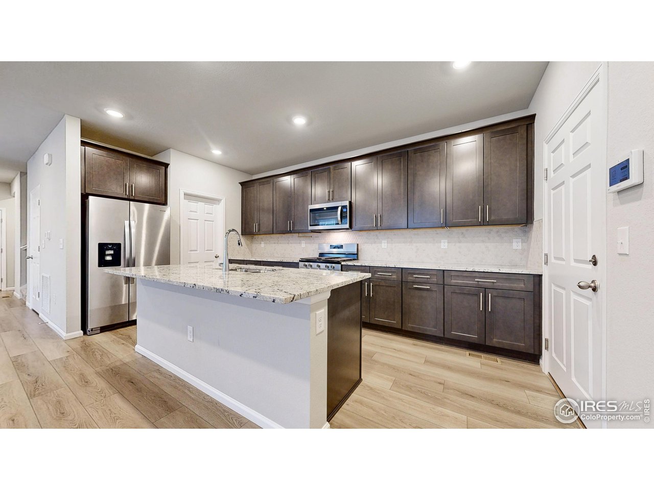 229 East 4th Street Berthoud, CO 80513 - Photo 12 of 49 a kitchen with kitchen island granite countertop stainless steel appliances cabinets a sink and a counter top space