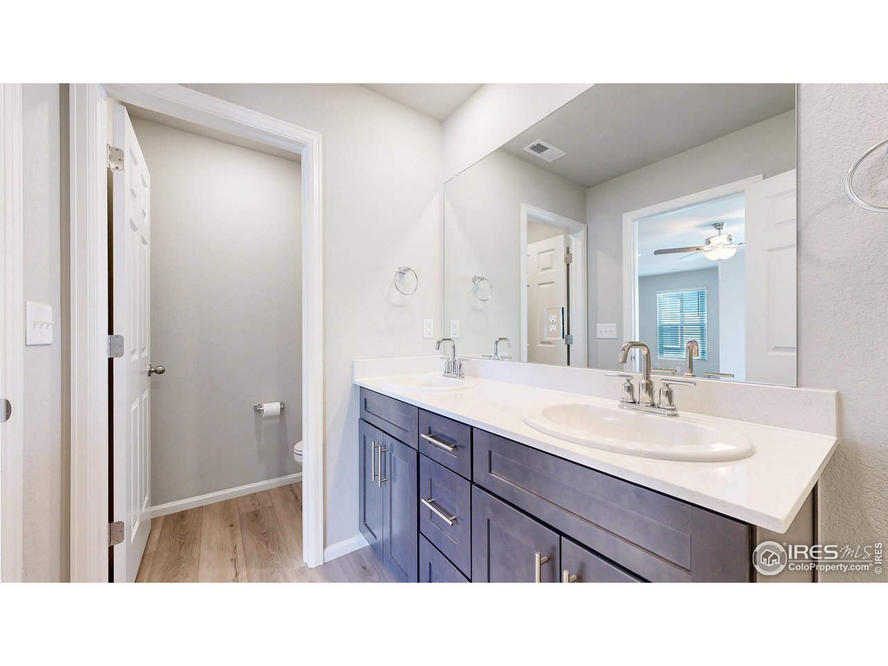 229 East 4th Street Berthoud, CO 80513 - Photo 29 of 49 a bathroom with a sink a mirror and a toilet