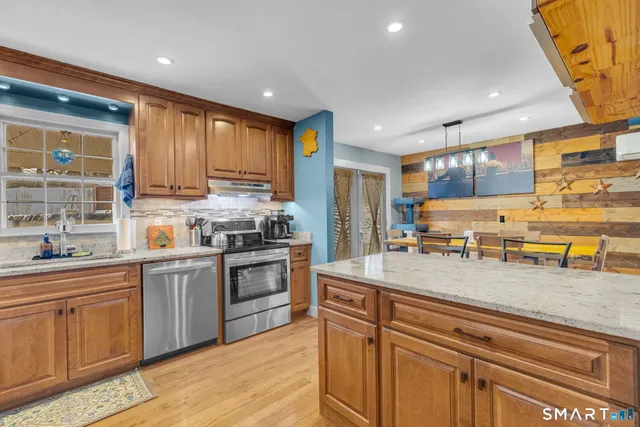 a kitchen with stainless steel appliances granite countertop a stove a sink and a refrigerator
