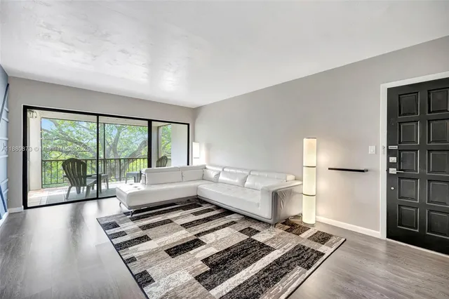 a living room with furniture and a floor to ceiling window