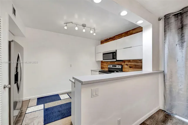 a view of kitchen with furniture and refrigerator
