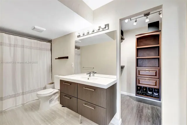 a bathroom with a sink a toilet and shower