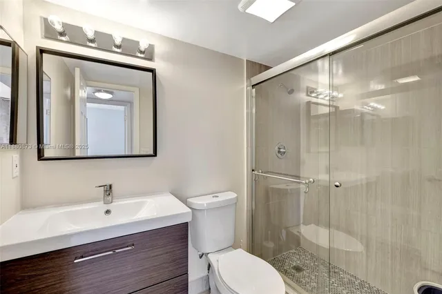 a bathroom with a toilet a sink a mirror and vanity