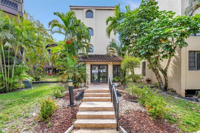 a front view of a house with a garden and trees