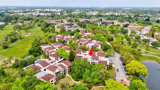 an aerial view of residential houses with outdoor space and trees