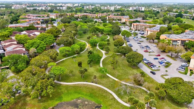 an aerial view of residential houses with outdoor space and trees all around