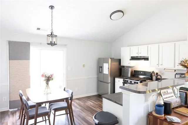 a kitchen with furniture a refrigerator and a dining table