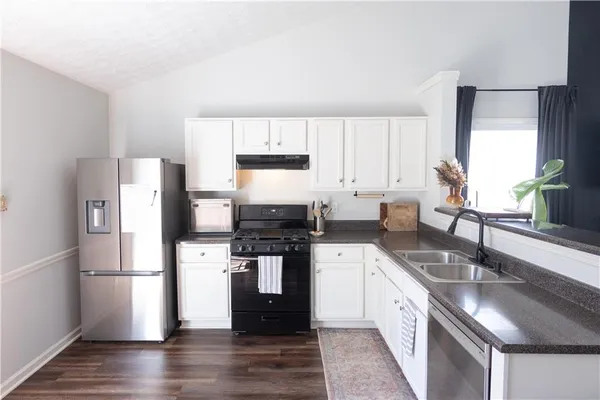 a kitchen with stainless steel appliances granite countertop a sink stove and refrigerator