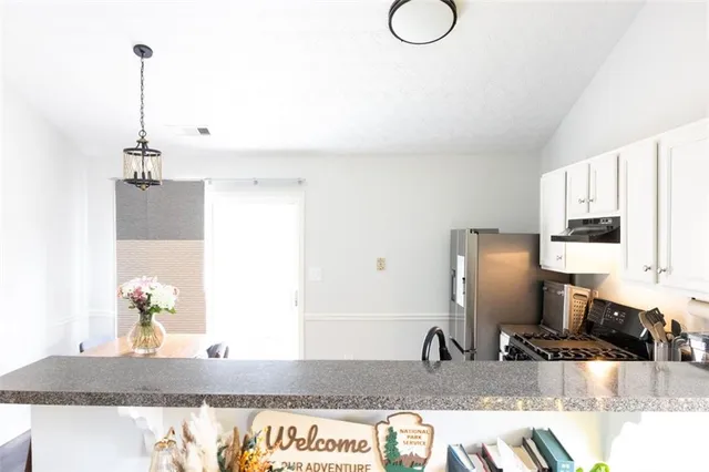 a kitchen with stainless steel appliances granite countertop a sink and a refrigerator
