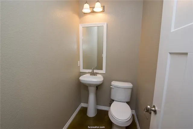 a bathroom with a toilet a sink and mirror