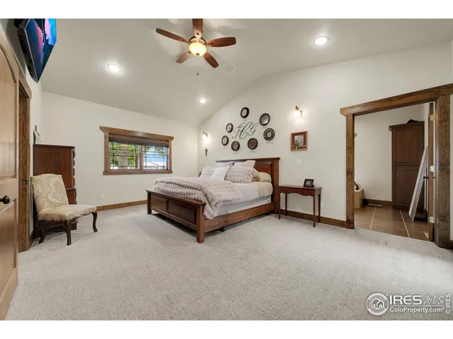 a spacious bedroom with a bed a couch and a chandelier