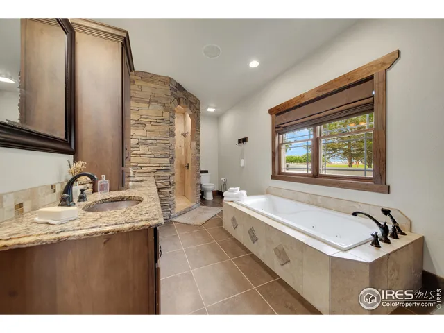 a bathroom with a tub sink and mirror