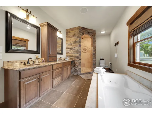 a bathroom with a granite countertop sink mirror and a bathtub