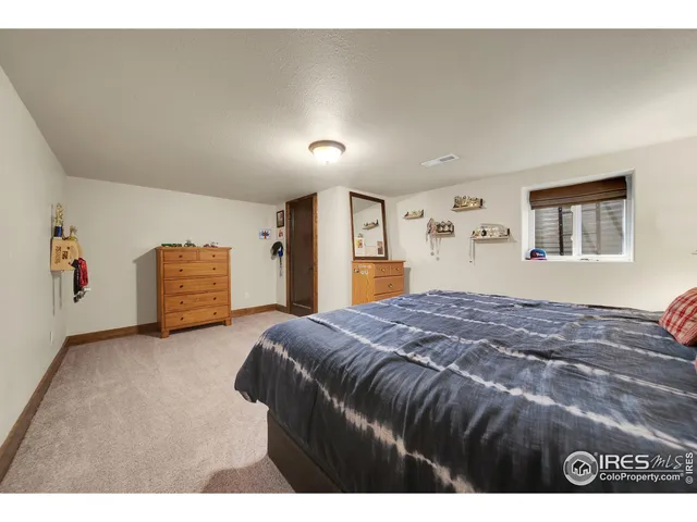 a bedroom with a bed and a large mirror