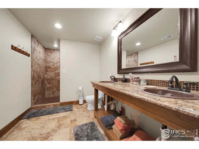 a bathroom with a granite countertop sink a mirror and shower
