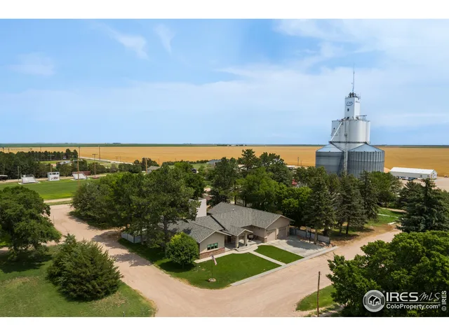 an aerial view of residential houses with outdoor space and trees