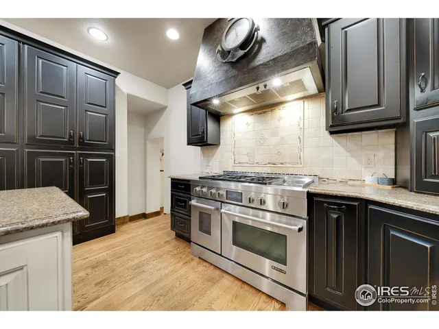 a kitchen with stainless steel appliances granite countertop a stove a microwave and a refrigerator
