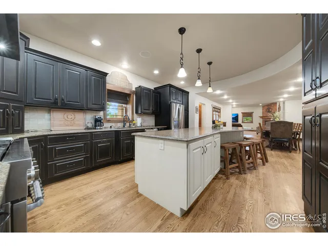 a kitchen with stainless steel appliances kitchen island granite countertop a stove top oven a sink a refrigerator and a microwave