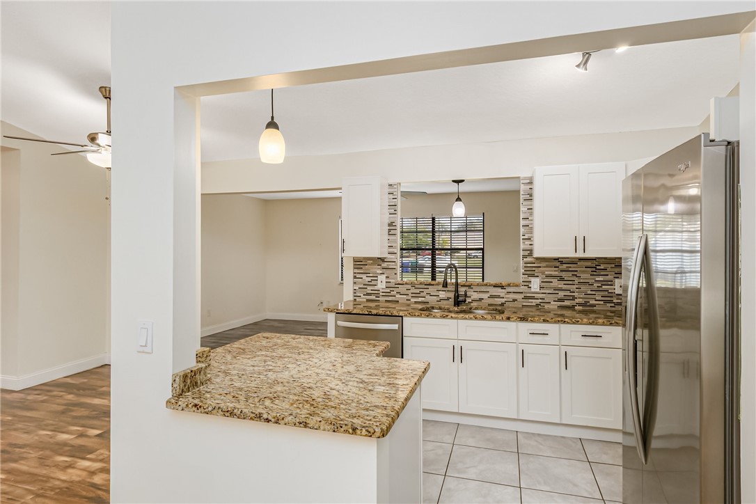 1121 Clearmont Street Sebastian, FL 32958 - Photo 13 of 31 a kitchen with kitchen island cabinets and refrigerator